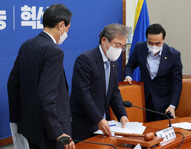 우상호 더불어민주당 비상대책위원장, 송기헌 중앙위원회 부의장, 박홍근 원내대표가 26일 서울 영등포구 여의동 국회에서 열린 중앙위원회에서 80조 등 당헌 개정 수정안을 상정한 후 퇴장하고 있다. 연합뉴스