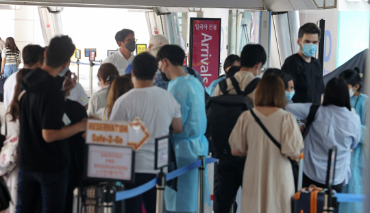 31일 오후 인천국제공항 제1여객터미널 입국자 전용 코로나19 검사센터에서 해외 입국자들이 검사를 위해 대기하고 있다. 정부는 내달 3일부터 국내에 입국하는 모든 내·외국인에 대해 입국 전 코로나19 PCR(유전자증폭) 음성 확인서 제출 의무를 중단하고 입국 후 1일 이내 PCR 검사만 유지하기로 했다. 연합뉴스