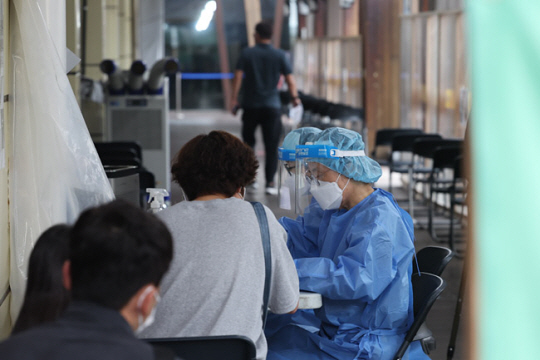 코로나19 신규 확진자 수가 감소세를 보이는 가운데 31일 오전 서울 송파구 보건소 선별진료소에서 시민들이 검사 순서를 기다리고 있다. 연합뉴스