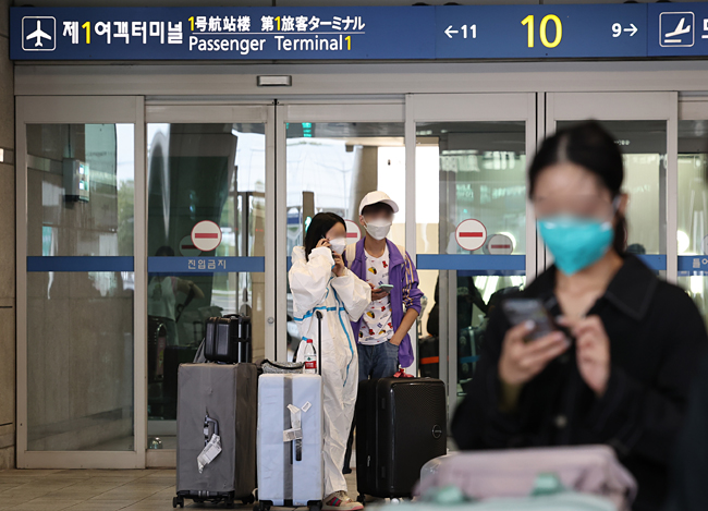 내달 3일부터 국내 입국자에 대한 코로나19 음성확인서 제출 의무가 폐지될 예정인 가운데 30일 인천국제공항 제1여객터미널에서 방역복을 입은 해외 입국자가 대기하고 있다. 연합뉴스
