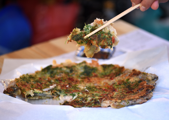 경남 창원시 마산부림시장 ‘명태전집’의 명태전. 번철에다 명태 한 마리를 펴고 밀가루 풀과 고추, 방아풀 등으로 옷을 입혀 통째로 부쳐내는 요리다.
