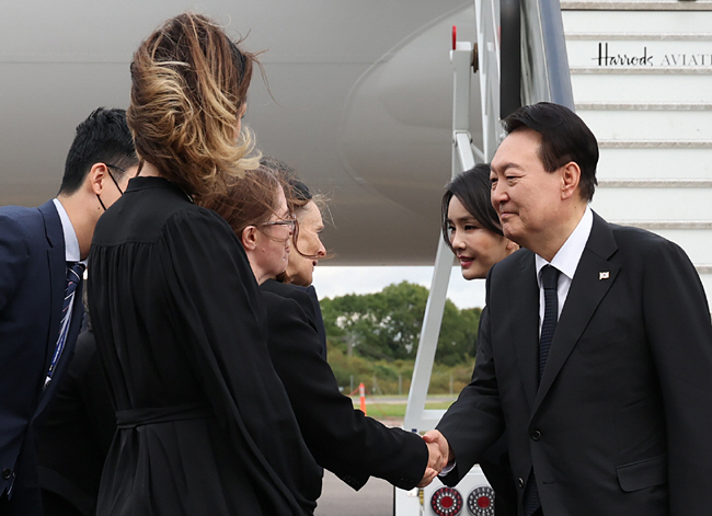 윤석열 대통령이 18일(현지시간) 영국 여왕의 장례식 참석을 위해 부인 김건희 여사와 함께 런던 스탠스테드공항에 도착해 영접을 나온 피오나 넬름스 국왕 특별대표 측과 악수하고 있다. 연합뉴스