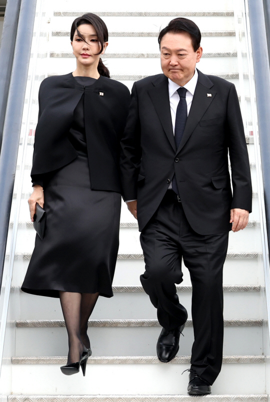 윤석열 대통령과 부인 김건희 여사가 18일(현지시간) 영국 런던 스탠스테드공항에 도착해 공군 1호기에서 내리고 있다. 윤 대통령 부부는 19일 런던 웨스트민스터 사원에서 엄수되는 엘리자베스 2세 영국 여왕의 장례식에 참석할 예정이다. 연합뉴스