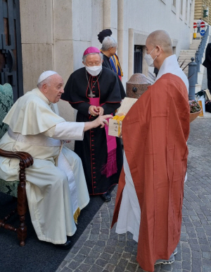 프란치스코 교황(왼쪽)이 지난 18일(현지시간) 교황청에서 한국 불교 대표인 원경 스님으로부터 한국 전통 도예 작품인 다관을 선물받고 큰 관심을 보이고 있다. 가운데는 김희중 천주교 대주교.  한국종교지도자협의회 제공