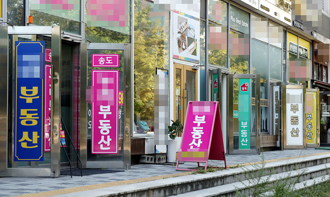 국토교통부가 세종시와 인천 연수·남동·서구 등 4곳을 투기과열지구에서 해제할 방침이라고 밝힌 21일 오후 인천시 연수구 송도국제도시 내 부동산 밀집 상가에 문이 활짝 열려 있다. 연합뉴스