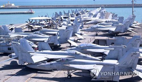 23일 부산 남구 해군작전사령부에 미 해군의 핵추진 항공모함 로널드 레이건호(CVN-76)가 입항한 가운데 갑판에 전투기가 탑재되어 있다. 연합뉴스. 사진공동취재단.