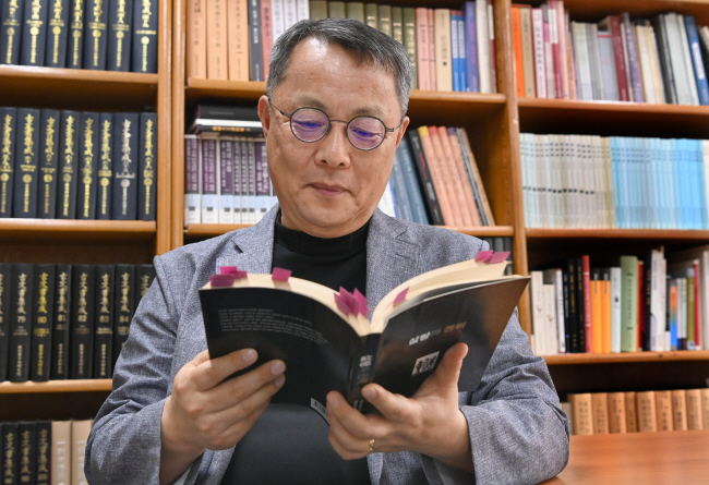 ‘음식 인문학자’인 주영하 한국학중앙연구원 교수가 지난 16일 경기 성남시 연구실에서 시드니 민츠의 ‘설탕과 권력’을 들여다보고 있다. 신창섭 기자