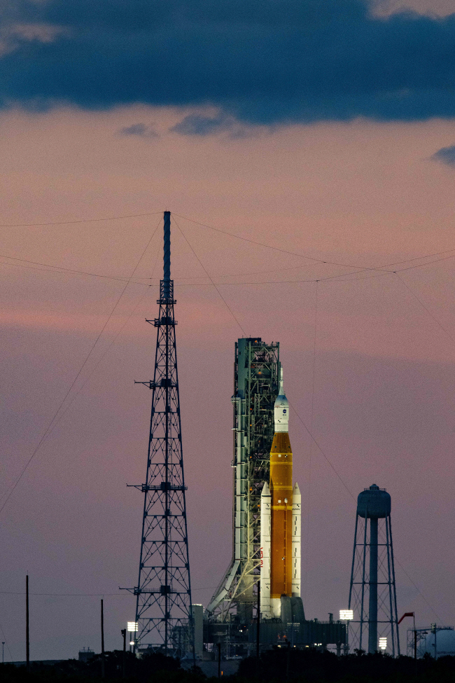 나사(미 항공우주국)의 달 탐사 프로젝트 ‘아르테미스 I’ 임무 로켓이 지난 25일 미국 플로리다주 케네디우주센터 발사대 위에 서 있다. 나사는 허리케인 북상을 이유로 27일 예정됐던 발사를 지난 8월 말 이후 3번째로 연기했다.  AFP 연합뉴스