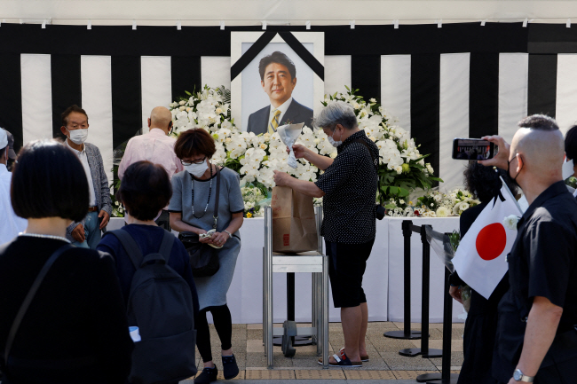 아베 신조 전 일본 총리의 국장이 열리는 27일 조문객들이 도쿄 지요다구 무도관 밖에 마련된 제단에 헌화하고 있다. 로이터 연합뉴스