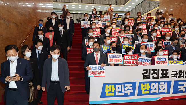 국민의힘 의원들이 지난 29일 국회 본관 계단에서 박진 외교부 장관 해임안에 항의하는 피켓 시위를 벌일 때 더불어민주당 의원들이 해임안 처리를 마친 뒤 본회의장에서 내려오고 있다. 공동취재사진