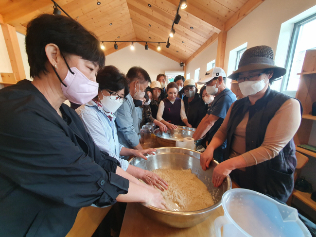 지난달 29일 전통주 제조·교육기업 ㈜오산양조 사업장에서 ‘신갈오거리부엌 막걸리&요리 학교’ 수강생들이 고두밥과 누룩을 섞으며 술을 빚고 있다.