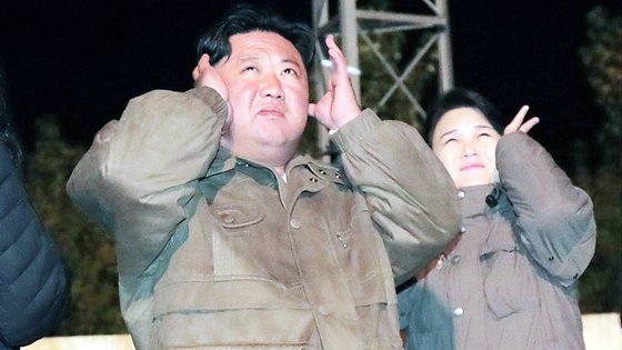 김정은 북한 국방위원장과 부인 이설주 여사가 초대형 방사포(KN-25) 발사 훈련을 지켜보며 폭발음에 얼굴을 찡그리며 귀를 막고 있다. 조선중앙통신 캡처/ 연합뉴스