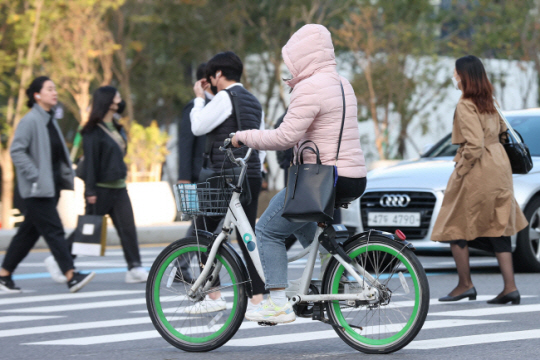 올 가을 들어 가장 낮은 기온을 기록한 11일 오전 서울 광화문 네거리에서 자전거를 탄 시민이 패딩으로 온몸을 감싼 채 횡단보도를 건너고 있다. 연합뉴스