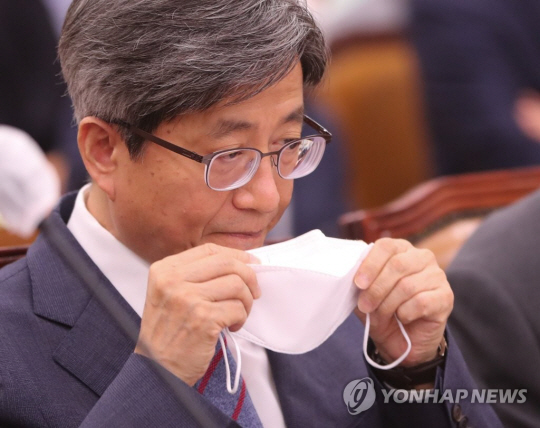 김명수 대법원장이 지난 4일 서울 여의도 국회에서 열린 대법원 등에 대한 법제사법위원회 국정감사에서 마스크를 고쳐쓰고 있다. 연합뉴스