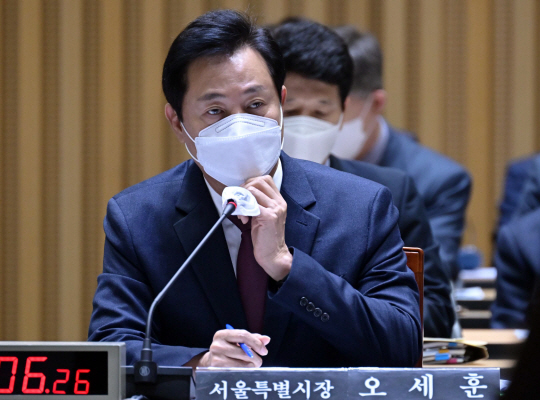 오세훈 서울시장이 12일 서울 중구 서울시청 대회의실에서 열린 국회 행정안전위원회 서울시 국정감사에서 마스크를 고쳐쓰고 있다. 뉴시스