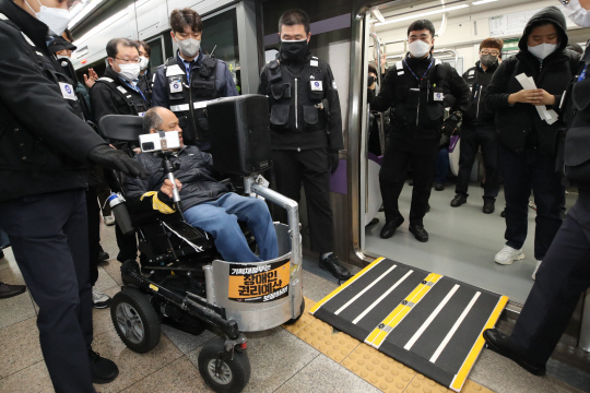 전국장애인차별철폐연대(전장연) 회원들이 지난 17일 서울 종로구 광화문역에서 장애인권리예산 등을 촉구하는 ‘제39차 출근길 지하철 탑니다’ 시위를 하고 있다. 뉴시스