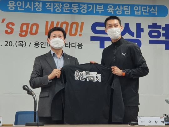 우상혁(오른쪽) 20일 용인 미르스타디움에서 열린 용인시청 직장운동경기부 육상팀 입단식에서 이상일 용인시장에게서 단복을 받고 있다. 연합뉴스
