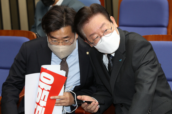 이재명(오른쪽) 더불어민주당 대표가 20일 오전 국회에서 열린 긴급 의원총회에 참석해 박찬대 최고위원과 귀엣말을 나누고 있다.   국회사진기자단