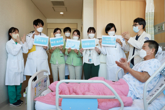 ▲서울성모병원 로봇수술센터 수술팀 등 교직원들이 18일 1만 번째 로봇수술 환자의 병실을 방문해 빠른 쾌유와 건강을 기원하고 있다. 서울성모병원 제공