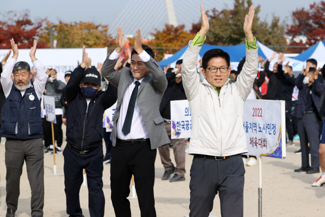 김문수(오른쪽) 경제사회노동위원회 위원장이 27일 오전 서울 영등포구 양화한강공원에서 열린 한국노총 서울지역본부 주관 체육대회에 참석해 참석자들과 준비운동을 하고 있다.  뉴시스