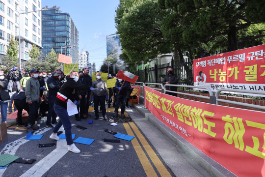 지난 25일 서울 영등포구 푸르밀 본사에 사업 종료에 항의하며 우유를 던지고 있다. 연합뉴스