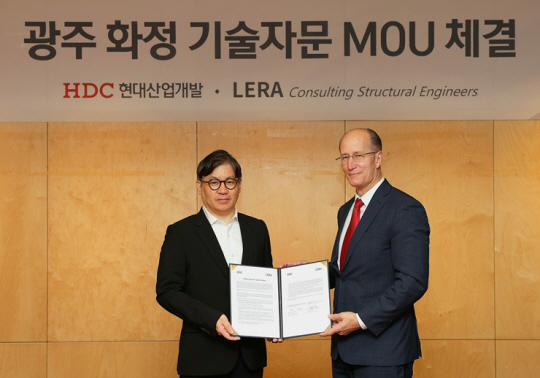 최익훈(왼쪽) HDC현대산업개발 대표이사와 미국 LERA社의 파트너인 William J. Faschan이 지난 14일 용산사옥에서 화정 아이파크 리빌딩 기술 자문을 위한 양해각서를 체결하고 있다. HDC현대산업개발 제공