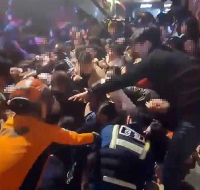 29일 오후 11시쯤 경찰과 소방요원들이 서울 용산구 해밀톤호텔 골목에서 깔려 있는 시민들을 구조하고 있다. 연합뉴스