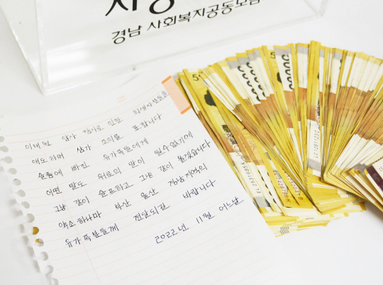 지난 2017년부터 신분을 숨긴 채 이웃돕기 등에 총 5억 원에 가까운 거금을 기탁한 한 익명의 남성이 7일 오전 경남사회복지공동모금회 사무실 앞 성금함에 이태원 참사 유가족에게 전달해달라며 또 1000만 원을 넣고 사라졌다. 사진은 익명 기부자가 성금함에 남긴 손편지와 승금. 연합뉴스·경남사회복지공동모금회 제공