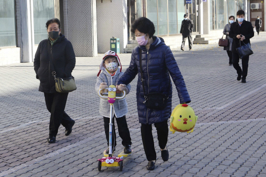 지난 3일 북한 평양에서 마스크를 쓴 할머니와 손자가 평양역 주변 거리를 걷고 있다. AP·뉴시스