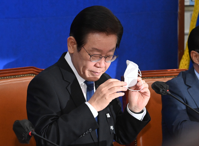 ‘대장동 특혜 개발 비리’ 의혹 사건으로 사법리스크 현실화에 직면한 더불어민주당 이재명 대표가 9일 오전 서울 여의도 국회에서 열린 최고위원회의에 참석해 모두발언을 하려고 마스크를 벗으면서 굳은 표정으로 시선을 아래로 향하고 있다. 김동훈 기자