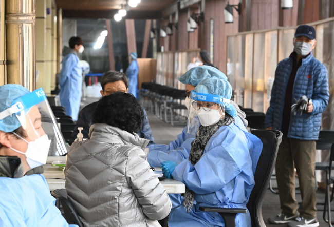 코로나19 누적 확진자가 2609만1539명을 기록한 11일 오전 서울 송파구보건소 선별진료소에서 시민들이 유전자증폭(PCR) 검사를 받기 위해 신청서를 제출하고 있다.  김호웅 기자