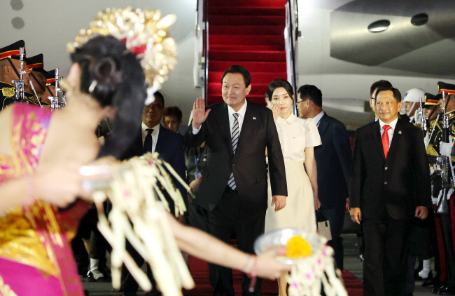 윤석열 대통령과 김건희 여사가 주요 20개국(G20) 정상회의 참석을 위해 14일 새벽 인도네시아 발리 응우라 라이 국제공항에 도착해 의장대 사열을 하면서 환영공연을 하는 전통 무용수에게 인사하고 있다.   연합뉴스
