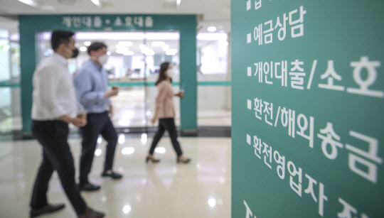 서울 시내 한 은행의 대출창구 옆을 직장인들이 지나고 있다. 뉴시스