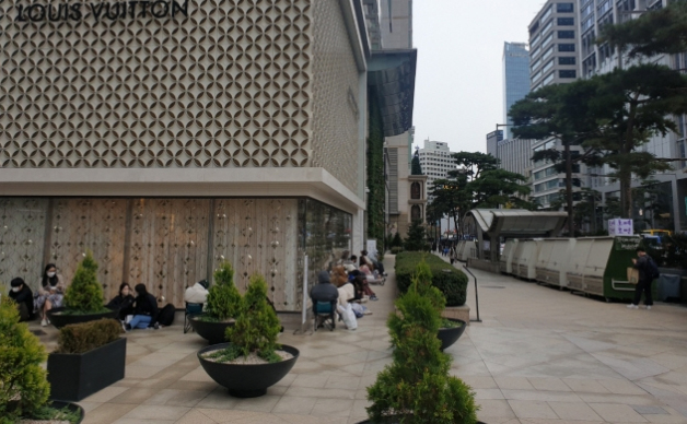 지난 16일 오전 7시쯤 서울 중구 소공동 롯데백화점 명품관 앞을 찾은 쇼핑객들이 샤넬·롤렉스 매장 입장을 기다리고 있다.