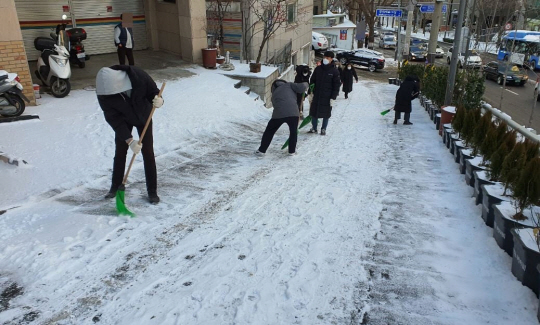 마포구 주민과 공무원들이 공덕동 경사로에서 제설작업을 하고 있다. 마포구청 제공