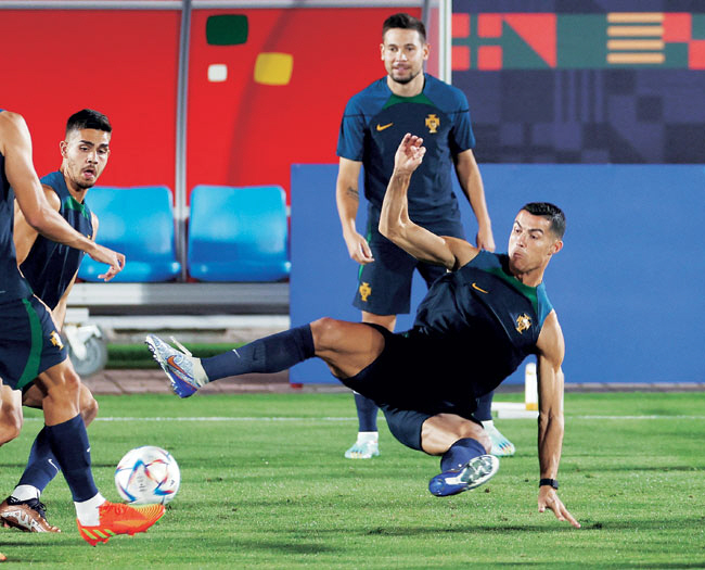 포르투갈의 크리스티아누 호날두(오른쪽)가 28일 오전(한국시간) 카타르 도하의 알샤하니야 스포츠클럽 트레이닝센터에서 열린 팀 훈련에서 공을 뺏기 위해 태클을 시도하고 있다.  로이터연합뉴스