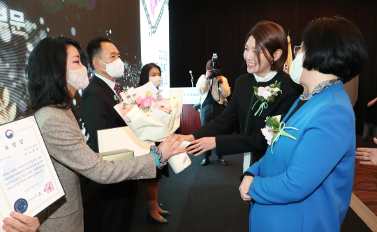 나눔홍보대사 최수영(오른쪽 두번째) 배우가 ‘2022 전국사회복지나눔대회’ 시상식 현장에서 보건복지부장관 표창 수상자에게 꽃다발을 전하고 있다. 한국사회복지협의회 제공