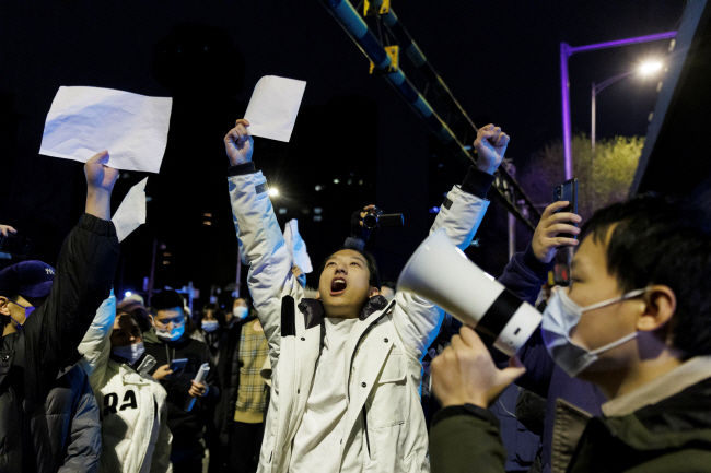 중국 당국의 3년여에 걸친 ‘제로 코로나’ 정책에 반대하는 중국인들이 28일 베이징 거리에서 일부는 마스크를 착용하지 않은 채 공산당의 검열·통제 반대를 의미하는 ‘백지’를 높이 들고 반정부 구호를 외치고 있다. 로이터 연합뉴스
