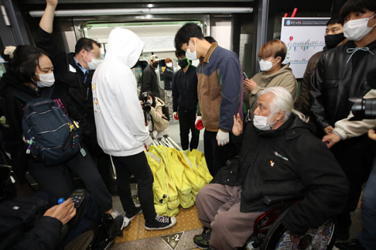 전국장애인차별철폐연대(전장연) 회원들이 21일 오후 서울 용산구 삼각지역 4호선 승강장에서 장애인 권리예산 반영 촉구 천막농성 선포 결의대회에서 교통공사의 천막 설치 불허에 항의, 지하철 출입문에 천막을 깔고 기습 시위를 하고 있다. 뉴시스