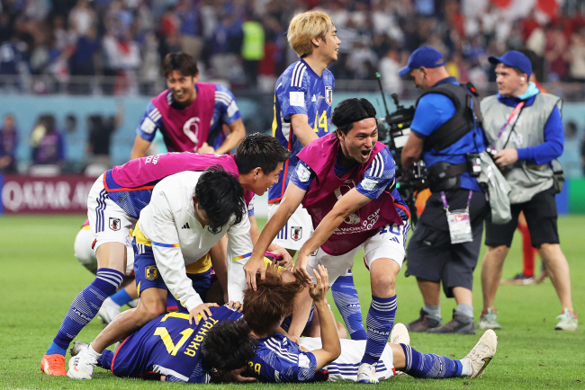 일본 축구대표팀 선수들이 2일 오전(한국시간) 카타르 도하의 칼리파 인터내셔널 스타디움에서 열린 스페인과 2022 카타르월드컵 E조 조별리그 3차전에서 2-1로 승리한 뒤 그라운드에 누워 환호하고 있다.  EPA 연합뉴스