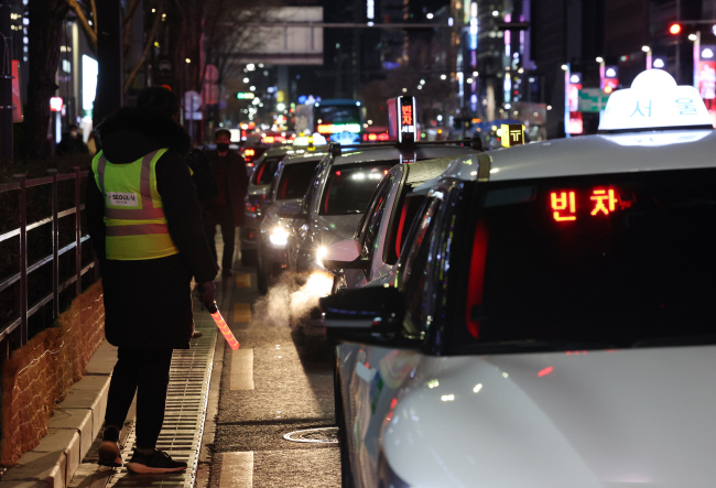 1일 서울 강남구 강남역 인근에서 ‘심야 택시 승차지원단’ 단원이 시민들의 택시 탑승을 돕고 있다. 서울시는 오는 23일까지 매주 목·금요일 유동 인구가 많은 시내 11개 지점에서 승차지원단을 운영한다.   연합뉴스