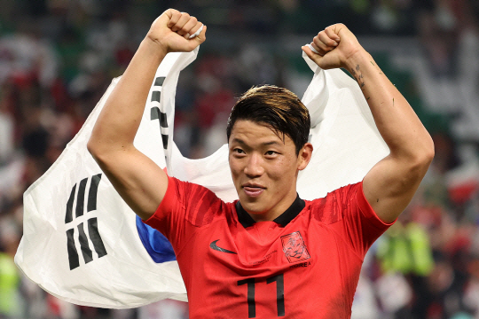 황희찬이 3일 오전(한국시간) 카타르 알라이얀의 에듀케이션시티 스타디움에서 열린 프로투갈과 2022 카타르월드컵 H조 조별리그 3차전에서 승리한 후 태극기를 두르고 환하게 웃고 있다. 뉴시스