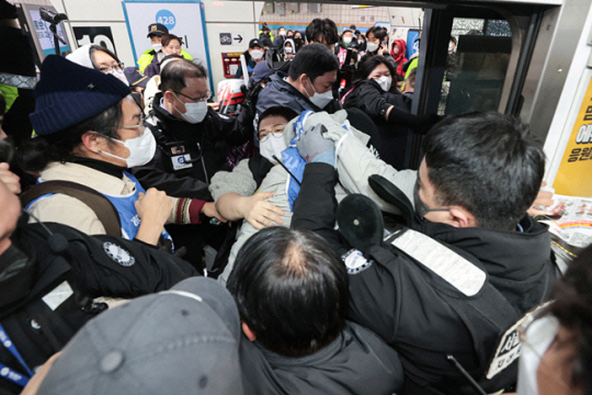 전국장애인차별철폐연대(전장연) 회원들이 지난 2일 오전 서울 4호선 삼각지역 플랫폼에서 지하철 탑승 시위 중 서울교통공사 지하철보안관 등과 충돌하고 있다. 연합뉴스
