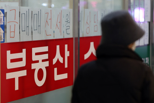 지난 9일 서울의 한 부동산중개업소 앞을 한 시민이 지나고  있다. 연합뉴스