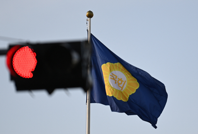 12일 오전 국회 앞에 걸린 국회 깃발 뒤편으로 더불어민주당을 비롯한 야권의 이상민 행정안전부 장관 해임건의안 처리 강행과 윤석열 대통령의 거부 상황에 따른 예산안 처리 난항을 시사하듯 빨간 신호등이 켜져 있다.  박윤슬 기자