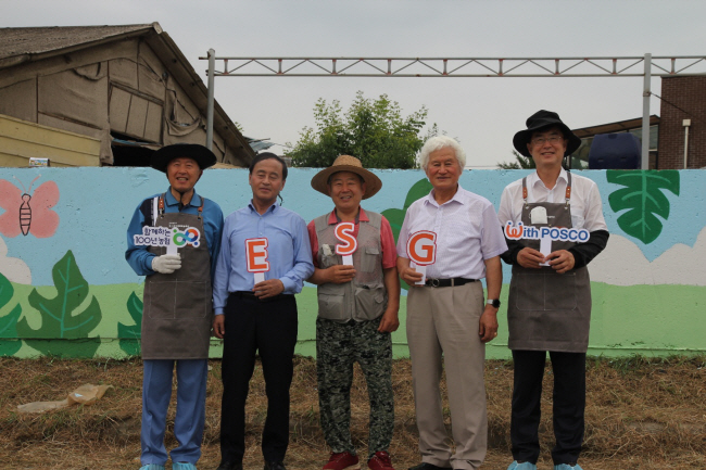 안병우(오른쪽 첫 번째) 농협 축산경제 대표가 김학용(〃 다섯 번째) 포스코모빌리티솔루션 대표와 축산농가 벽화 그리기 행사에서 주민들과 기념촬영을 하고 있다.