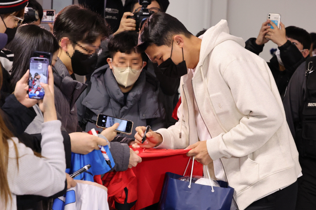 축구대표팀의 수비수 김민재가 14일 밤 인천국제공항에서 출국을 앞두고 팬들에게 사인을 해주고 있다.  연합뉴스