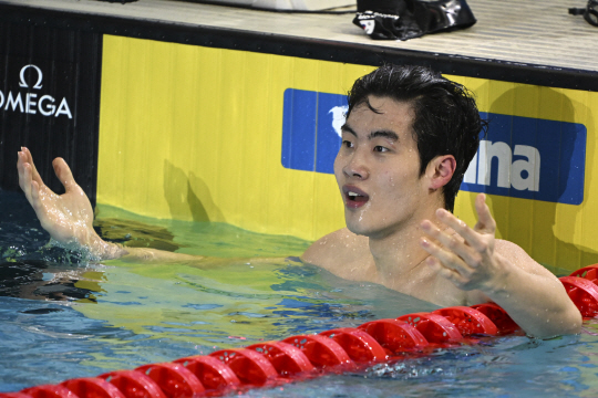 황선우가 18일 호주 멜버른 스포츠 앤드 아쿠아틱 센터에서 열린 쇼트코스 세계수영선수권 대회 남자 자유형 200m 결승에서 1위를 한 후 자신의 기록을 보며 놀라고 있다. AP 연합뉴스