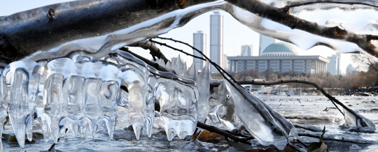 수도권 지역 한파특보가 발효된 18일 오전 서울 여의도 인근 한강변에 꽁꽁 언 고드름 너머로 국회가 보이고 있다.  박윤슬 기자