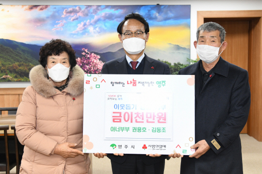 전국 최초 ‘농민 부부’ 아너 소사이어티 회원인 경북 영주시 권용호(오른쪽)·김동조(왼쪽) 씨 부부가 19일 영주시청에서 이웃돕기 성금을 맡긴 뒤 박남서(중간) 영주시장과 사진을 촬영하고 있다. 영주시청 제공